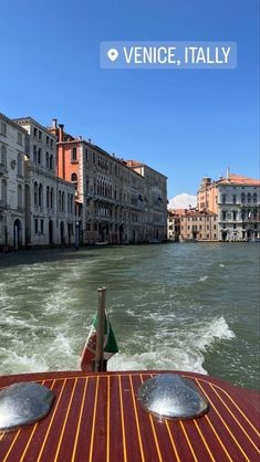 the back end of a boat traveling down a river in venice, italy with buildings on both sides