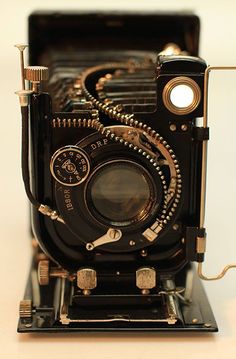 an old fashioned camera sitting on top of a table