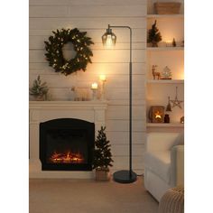 a living room with a fire place and christmas wreaths on the fireplace mantel