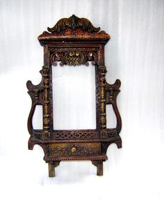 an old wooden frame with carvings on the front and sides, sitting against a white background