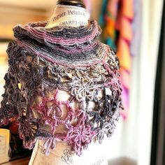 a mannequin is adorned with crocheted scarves