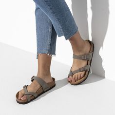 With an effortless crisscross forming a single loop around the toe, we bring you the elegantly functional Mayari sandal. Classic support and adjustability delivered beautifully. Birkibuc is a durable, synthetic upper material with a nubuck leather-like texture and a soft backing Contoured cork footbed conforms to the shape of your foot and features pronounced arch support, a deep heel cup, and a roomy toe box; lined with suede Lightweight EVA sole for cushioning and shock absorption Made in Germ Birkenstock Mayari Outfit, Stone Birkenstock, Modern Sandals, Birkenstock Women, Footbed Sandals, Birkenstock Mayari, American Shirts, Nubuck Leather, Thong Sandals