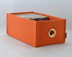 an orange storage box with cd's in it