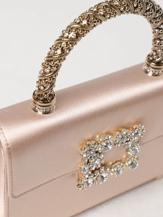 Find ROGER VIVIER Mini Bag on Editorialist. The Roger Vivier mini bag features a top handle, a buckle closure, and a detachable chain strap. The bag is crafted from satin and embellished with crystals. It is small in size and can be worn on the shoulder or hand carried. The bag is perfect for evening events. Luxury Event Clutch With Top Handle, Luxury Shoulder Bag For Events, Luxury Blush Shoulder Bag With Dust Bag, Luxury Embellished Event Bags, Luxe Evening Bag With Top Handle, Luxury Evening Bag With Pearl Handle For Events, Luxury Handheld Evening Bag, Luxury Top Handle Evening Bag For Events, Luxury Top Handle Shoulder Bag For Events