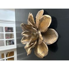 a metal flower mounted to the side of a wall