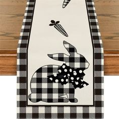 a black and white table runner with an image of a rabbit on it's back