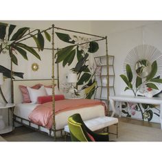 a bedroom decorated in white and pink with lots of greenery on the wall behind the bed