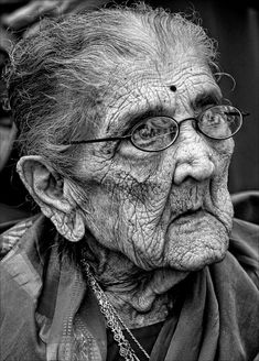 an old woman with glasses looking at the camera