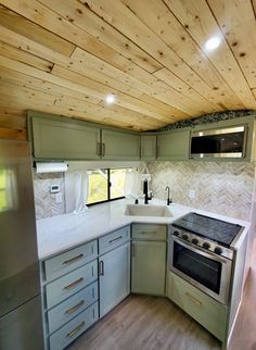 an empty kitchen with wood paneling on the ceiling