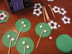 soccer themed cupcakes and marshmallow toppers on a table with sticks