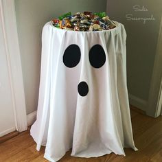 a white table with black polka dots on it and a ghost decoration in the middle