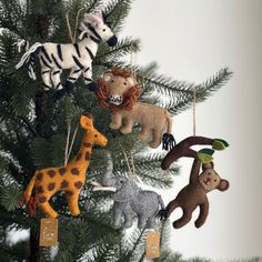 the ornaments are hanging from the tree in the shape of giraffes and zebras