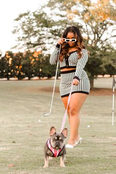 a woman is walking her dog on a leash in the park while wearing goggles