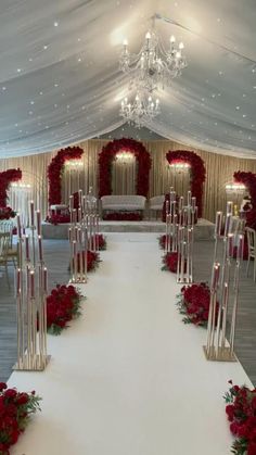 a wedding ceremony setup with red flowers and candles