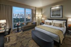 a hotel room with a large bed, chair and desk in front of the window