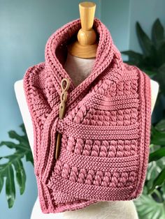 a pink knitted shawl on a mannequin