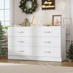 a white dresser sitting next to a christmas tree