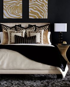 a black and gold bedroom with zebra prints on the wall above the bed, along with two lamps