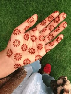 a person's hand with hendix on it and grass in the background