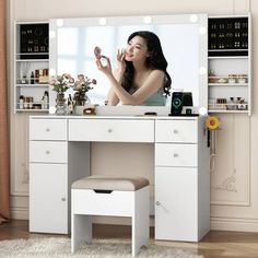 a woman sitting at a vanity looking in the mirror