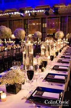 a long table is set up with candles and place settings for an elegant wedding reception