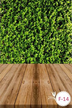 a wooden table with a green hedge behind it