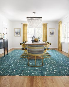 a dining room table with chairs and a chandelier hanging from the ceiling above it