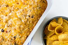 a casserole dish with tortilla chips next to it