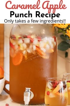 a pitcher filled with liquid sitting on top of a counter next to a bowl of fruit