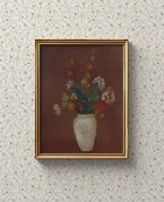 a painting hanging on the wall above a vase with flowers