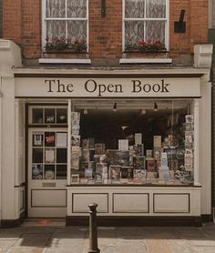 the open book store is located in front of a brick building