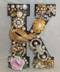 the letter k is decorated with pearls, jewels and other things to decorate on it