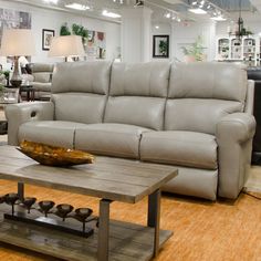 a living room with couches and tables in it's center area at a furniture store