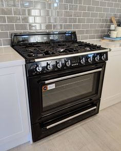 a black stove top oven sitting inside of a kitchen next to a white countertop