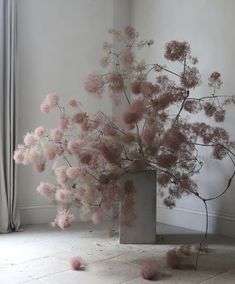 a vase with pink flowers in it sitting on the floor