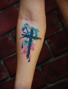 a person with a cross tattoo on their arm