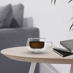 a cup of coffee sitting on top of a wooden table next to a gray couch