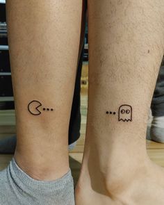 two people with matching tattoos on their legs, one has a pacman and the other has a ghost