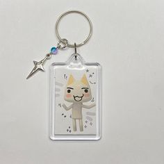 a keychain with an image of a cat on it's side and a star in the background