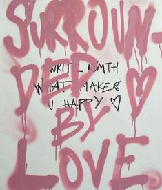 graffiti written on the side of a white wall with pink spray paint and words below it