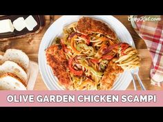 a white plate topped with pasta and meat next to bread on top of a wooden table