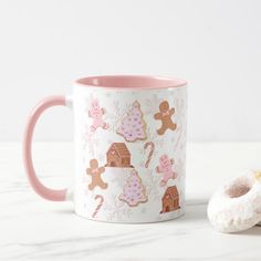 a pink and white coffee mug next to a donut