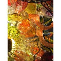 many different colored glass objects are arranged in the shape of an abstract pattern on top of each other