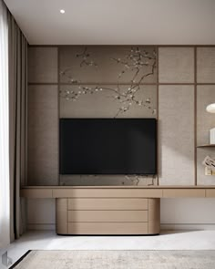 a tv is mounted on the wall in front of a vase with flowers and branches