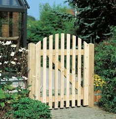 a wooden gate in the middle of a garden