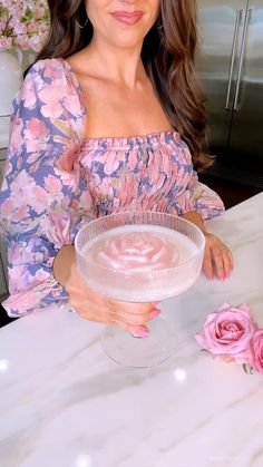 a woman sitting at a table holding a bowl