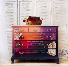 a dresser with flowers painted on it and a basket full of flowers sitting on top