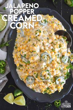 a black plate topped with corn covered in cheese and garnished with cilantro