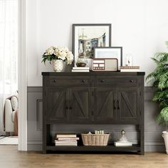 a living room with a potted plant and pictures on the wall next to it