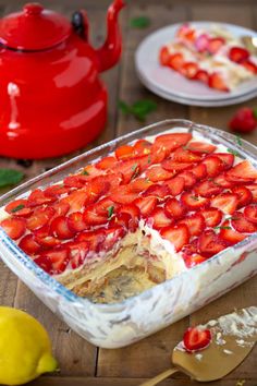 strawberry limoo trifle in a glass casserole dish on a wooden table